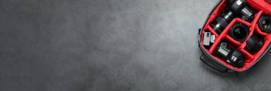 Gri taş masada sırt çantasındaki profesyonel fotoğraf ekipmanları, yazı için yeri olan üst manzara. Pankart tasarımı