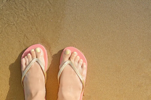 Woman wearing stylish flip flops on sandy beach, top view. Space for text
