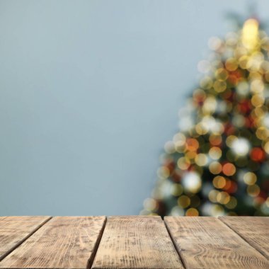 Boş ahşap masa ve bulanık güzel Noel ağacı manzarası. Tasarım için boşluk