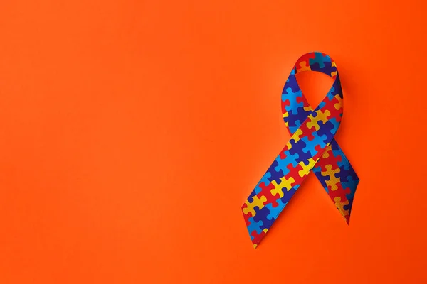 Всемирный День Осознания Аутизма Красочная Лента Головоломки Оранжевом Фоне Вид — стоковое фото
