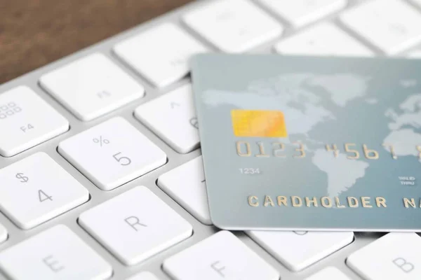 Online payment concept. Bank card on computer keyboard, closeup