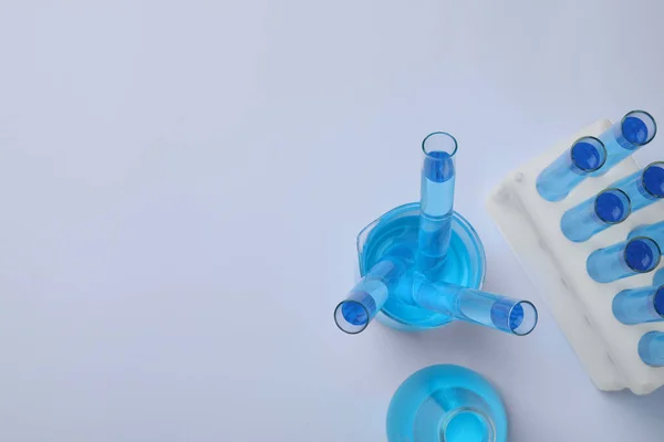 Laboratory Glassware Blue Liquid Light Grey Background Flat Lay Space — Fotografia de Stock
