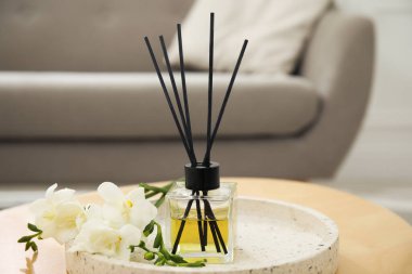 Reed diffuser with freesia on table in living room