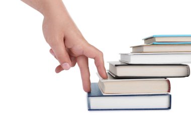 Woman imitating stepping up on books with her fingers against white background, closeup