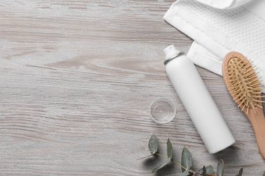 Bir şişe kuru şampuan, okaliptüs, ahşap masa üzerinde fırça ve havlu. Metin için boşluk