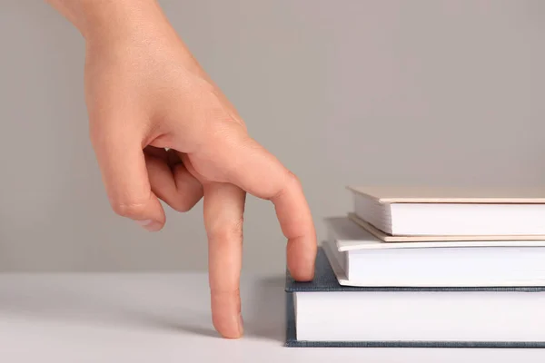 Woman Imitating Stepping Books Her Fingers Grey Background Closeup — Foto de Stock