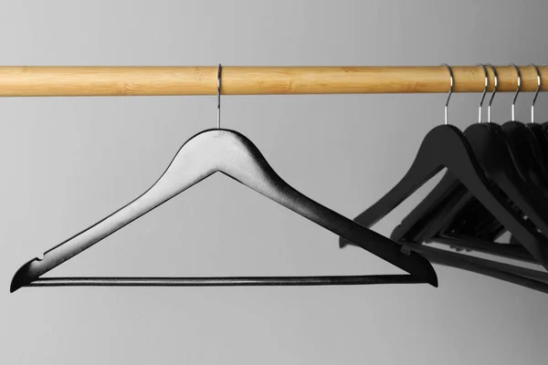 Black Clothes Hangers Wooden Rail Light Grey Background — Fotografia de Stock