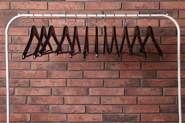 Zwarte Kleerhangers Rek Bij Rode Bakstenen Muur Ruimte Voor Tekst — Stockfoto