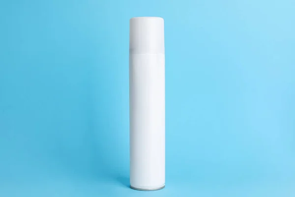 Bottle of dry shampoo on light blue background