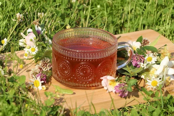 Ornate Glass Cup Tea Different Wildflowers Herbs Wooden Board Meadow — Stockfoto