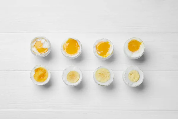Different Readiness Stages Boiled Chicken Eggs White Wooden Table Flat — Stockfoto