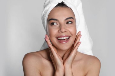 Kafasında havluyla arka planda güzel bir kadın.