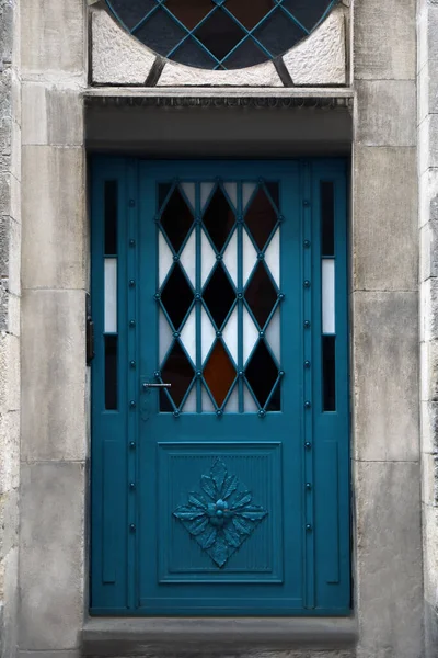 View of building with blue leaded glass door. Exterior design