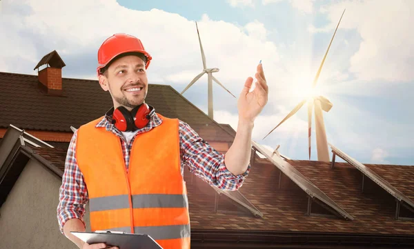 Ipari Mérnök Egyenruhában Kilátás Szélenergia Turbinák Közelében Ház Beépített Napelemek — Stock Fotó