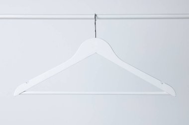 Beyaz elbiseler arka planda metal raylarda asılı duruyor.