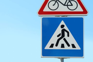 Güneşli bir günde Pedestrian Crossing ve No Bikes trafik levhaları ile mavi gökyüzüne