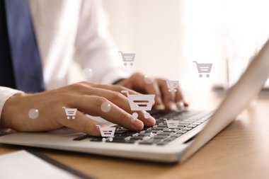 Delivery concept. Man using modern laptop for online shopping indoors, closeup. Market cart illustrations