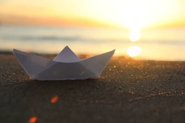 日落时 白纸船停泊在海边的沙滩上 案文的篇幅 — 图库照片