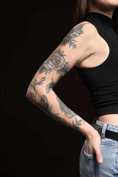 Vacker Kvinna Med Tatueringar Armen Mot Svart Bakgrund Närbild — Stockfoto