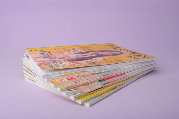 Группа упакованных журналов на фиолетовом фоне
