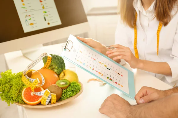 Joven Nutricionista Consultando Paciente Mesa Clínica Primer Plano —  Fotos de Stock