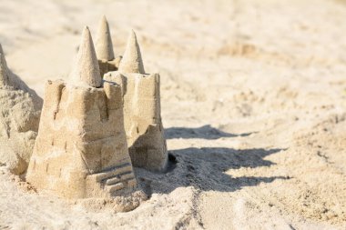 Beach with sand castle on sunny day. Space for text