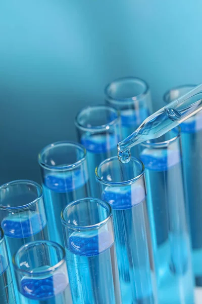 Druppelend Reagens Reageerbuis Lichtblauwe Achtergrond Close Laboratoriumanalyse — Stockfoto