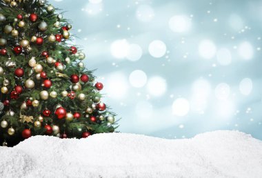 Güzel dekore edilmiş Noel ağacı ve açık mavi arka planda kar, yazı için yer. Bokeh etkisi