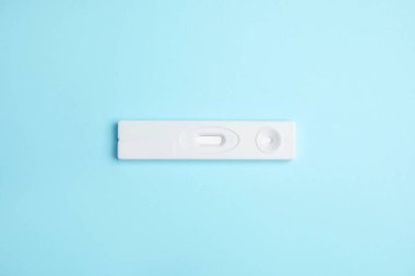 Açık mavi arka planda hepatit için tek kullanımlık ekspres test, üst görünüm