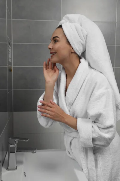 Mooie Jonge Vrouw Badjas Met Handdoek Hoofd Buurt Spiegel Thuis — Stockfoto