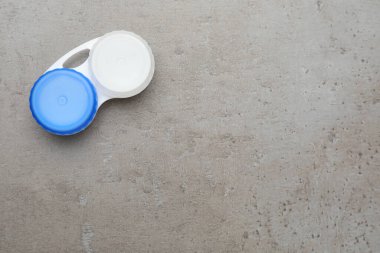 Gri masadaki kontakt lensli çanta, üst manzara. Metin için boşluk