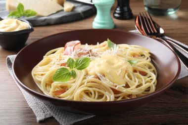 Peynir soslu lezzetli spagetti ve ahşap masada et.