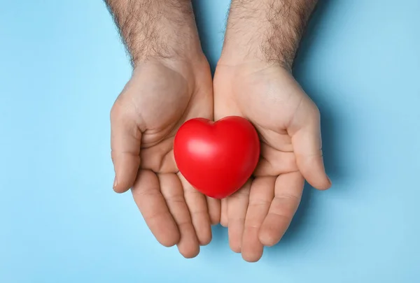 Man Holding Red Heart Light Blue Background Top View — Φωτογραφία Αρχείου