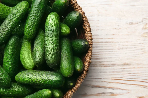 Fresh Ripe Cucumbers Wicker Basket White Wooden Table Top View — Stock Photo, Image