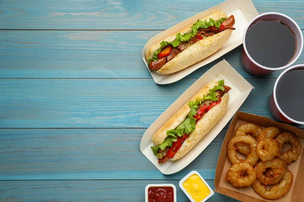 Smaczne Hot Dogi Smażone Krążki Cebulowe Sosy Orzeźwiający Napój Jasnoniebieskim — Zdjęcie stockowe