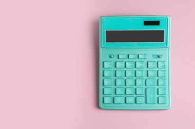 Turquoise calculator on pink background, top view. Space for text