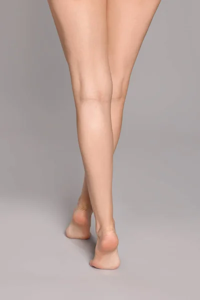 Женщина Красивыми Длинными Ногами Сером Фоне Крупным Планом — стоковое фото