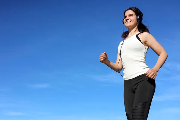 Young Woman Listening Music While Running Outdoors Morning Low Angle Stock Picture