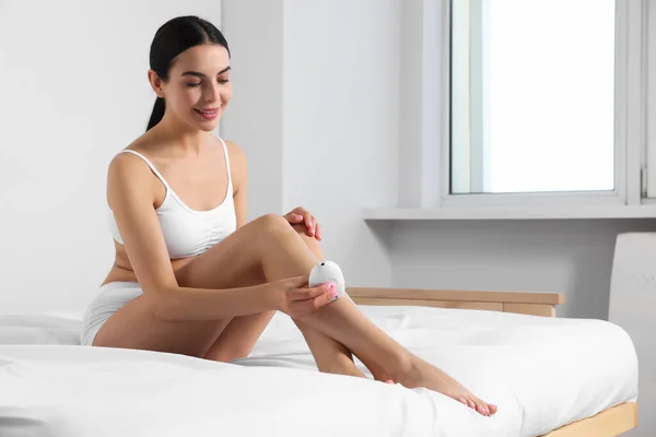 Young Woman Epilating Her Legs Bed — Φωτογραφία Αρχείου