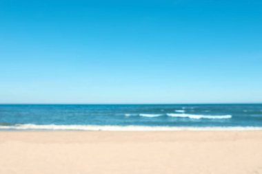 Güneşli bir günde bulanık deniz ve kumlu plaj manzarası