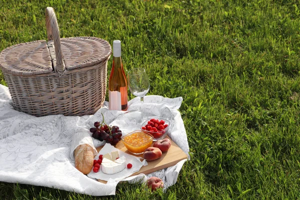 Picnic Blanket Tasty Food Basket Cider Green Grass Outdoors — Fotografia de Stock