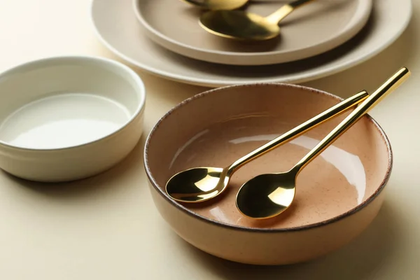 Stylish Empty Dishware Spoons Beige Background Closeup — Φωτογραφία Αρχείου