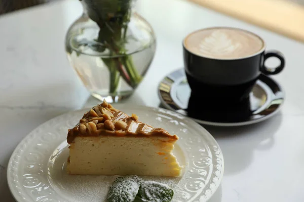 Tasty dessert and cup of fresh coffee on white table