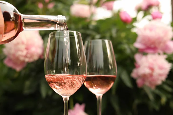 Ρίχνει Ροζέ Κρασί Από Μπουκάλι Ποτήρι Ενάντια Όμορφες Παιώνιες Closeup — Φωτογραφία Αρχείου