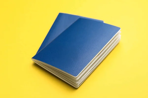 Two Blank Blue Passports Yellow Background Closeup — ストック写真