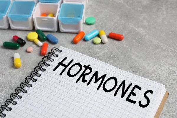 Notebook Word Hormones Pills Grey Table Closeup — 图库照片