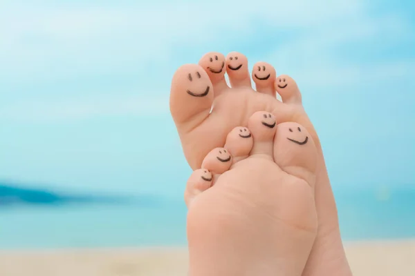 Woman with smiling faces drawn on toes outdoors, closeup of feet. Space for text