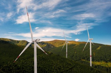 Güneşli bir günde dağlarda modern rüzgar türbinleri. Alternatif enerji kaynağı