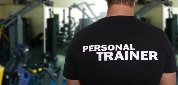 Professional personal trainer in gym, space for text. Banner design