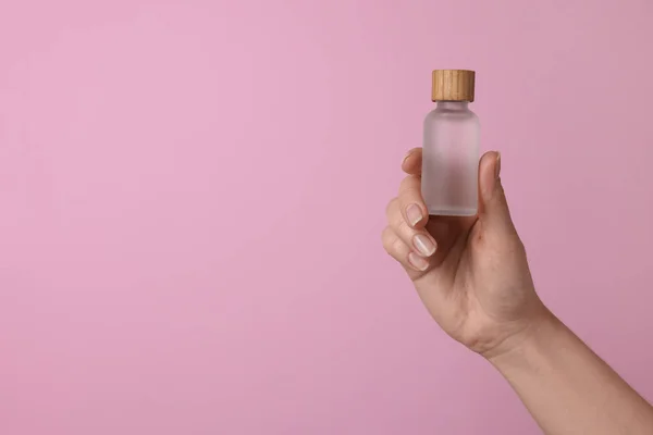 Woman Holding Bottle Cosmetic Product Pink Background Closeup Space Text — Stock fotografie